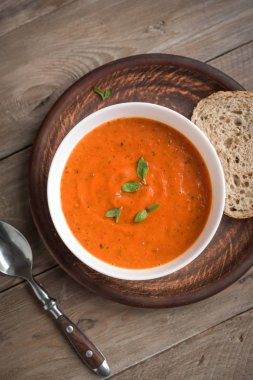 Ahşap masa, üstten görünüm, kopya alanı domates çorbası. Kabın içinde ev yapımı domates çorbası.