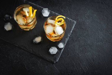 Viski ya da buzlu rom Limon twist siyah taş zemin, üstten görünüm, kopya alanı.