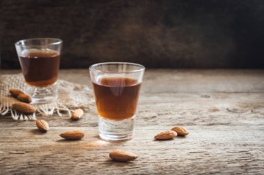 İtalyan likörü Amaretto badem rustik ahşap arka plan, kopya alanı ile