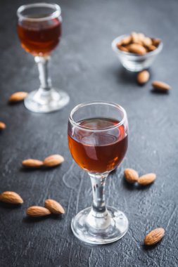 İtalyan likörü Amaretto badem siyah taş arka planda, kopya alanı ile