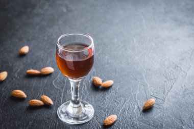 İtalyan likörü Amaretto badem siyah taş arka planda, kopya alanı ile