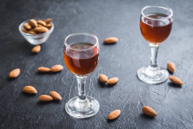 İtalyan likörü Amaretto badem siyah taş arka planda, kopya alanı ile