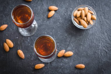 İtalyan likörü Amaretto badem siyah taş arka planda, üstten görünüm ile