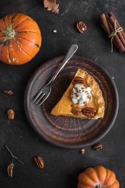 Krem şanti, pekan somun ve rustik zemin üzerine tarçın ile kabak pasta top görünümü, kopya alanı. Şükran günü - kabak pasta parçası için ev yapımı sonbahar pasta.
