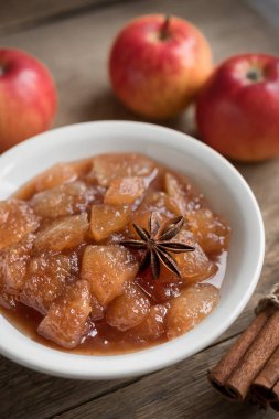 Ev yapımı elma Chutney (elma reçel, marmelat, tıknaz sos) tarçın, anason ve elma rustik zemin üzerine kapatın. Geleneksel sonbahar elma reçel.