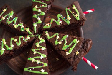 Çikolatalı Brownie yeşil buzlanma ve şenlikli şeker ile Noel ağacı şeklinde kapatın. Tatlı ev yapımı Noel ya da kış tatil Pastacılık gıda kavramı.
