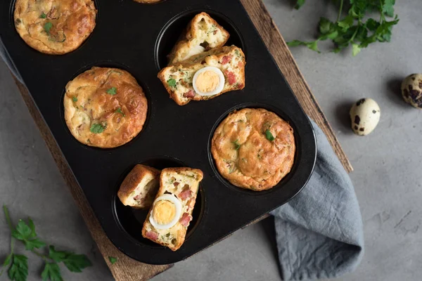 Protein breakfast egg muffins with quail egg, bacon and cheese. High protein and fat muffins for ketogenic or paleo diet, top view.