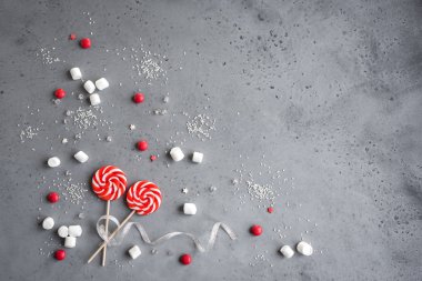 Kırmızı ve beyaz mevsimlik kış tatlılar, şekerler ve marshmallow ile Noel kompozisyon, düz gri, kopya alanı üzerinde yatıyordu. Noel tebrik kartı, desigh, kavram.