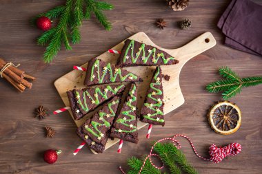 Yeşil buzlanma ve şenlikli sprinkles ahşap masa, üstten görünüm üzerinde Noel ağaçları şeklinde çikolata kek alanı kopyalayın. Tatlı ev yapımı Noel ya da kış tatil Pastacılık gıda kavramı.