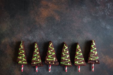 Yeşil buzlanma ve şenlikli sprinkles, üstten görünüm, Noel ağaçları şeklinde çikolata kek alanı kopyalayın. Tatlı Noel ya da kış tatil Pastacılık gıda kavramı.