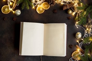 Vintage boş açık kitap, dekor, ışık ve köknar dallarda karanlık tablo, üstten görünüm ile Noel arka plan. Boş kopya alanı için metin düzeni.