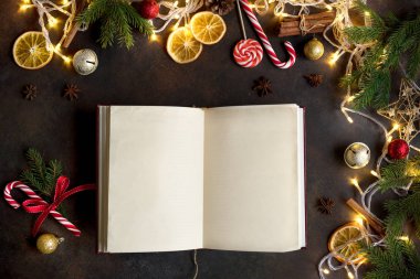 Vintage boş açık kitap, dekor, ışık ve köknar dallarda karanlık tablo, üstten görünüm ile Noel arka plan. Boş kopya alanı için metin düzeni.