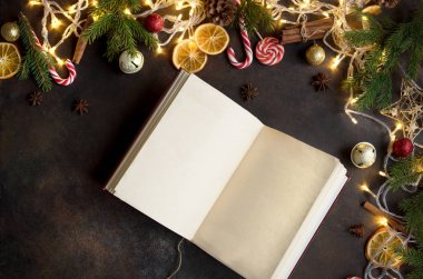 Vintage boş açık kitap, dekor, ışık ve köknar dallarda karanlık tablo, üstten görünüm ile Noel arka plan. Boş kopya alanı için metin düzeni.