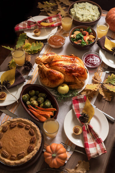 Thanksgiving Turkey Dinner with All the Sides. Homemade Roasted Turkey and all traditional dishes on Festive Thanksgiving table with autumnal decor.