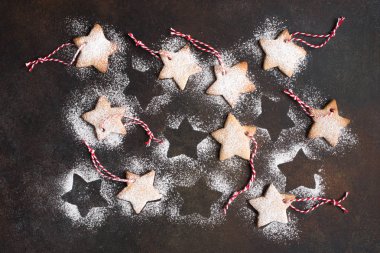 Noel yıldızı gingerbread çerezleri kırmızı ipler ve Noel ağacı süsle rustik arka planda, üstten görünüm için altın top şeklinde.