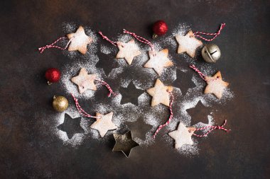 Noel yıldızı gingerbread çerezleri kırmızı ipler ve Noel ağacı süsle rustik arka planda, üstten görünüm için altın top şeklinde.