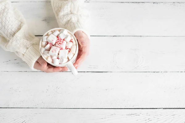 Weihnachtsschokolade Mit Marshmallows Pfefferminzbonbons Den Händen Auf Weißem Tisch Draufsicht — Stockfoto