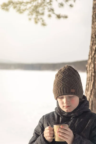 微笑的十几岁的男孩穿着温暖的衣服与热的冬季饮料 关闭肖像与白雪户外在冬季 家庭冬季周末或假期 冬季乐趣 活动和健康休假的概念 — 图库照片