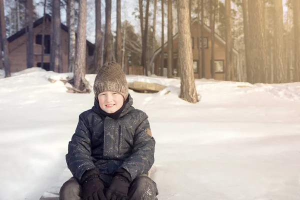 Χαριτωμένο Εφηβικό Αγόρι Κάθεται Στο Λευκό Χιόνι Χαμογελώντας Εξωτερική Κοντά — Φωτογραφία Αρχείου