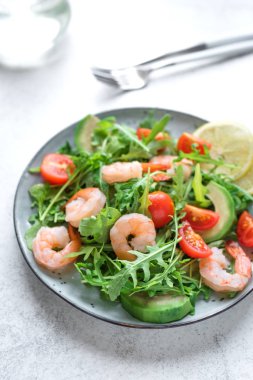 Avokado karides roka salatası beyaz taş zemin üzerine alan kopyalayın. Sağlıklı diyet yeşil salata karides (karides), avokado ve roka ile.