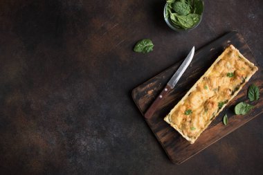 Rustik koyu arka plan üzerine peynir ile ıspanak pasta (quiche) somon. Sağlıklı yemek, üstten görünüm, kopya alanı için ev yapımı somon tart.