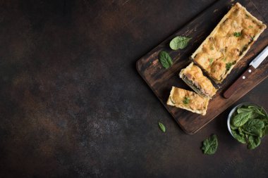 Rustik koyu arka plan üzerine peynir ile ıspanak pasta (quiche) somon. Sağlıklı yemek, üstten görünüm, kopya alanı için ev yapımı somon tart.