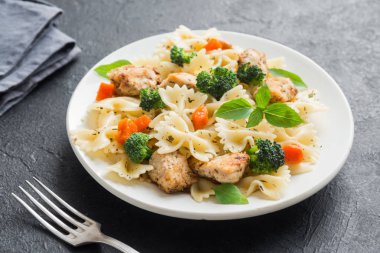 Farfalle makarna Tavuk ve sebze ile. Siyah arka plan, kopya alanı üzerine makarna salatası.