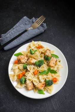 Farfalle makarna Tavuk ve sebze ile. Siyah arka plan, kopya alanı üzerine makarna salatası.