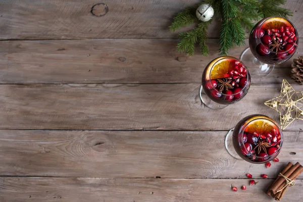 Red Sangria with oranges, pomegranate seeds, cranberry, rosemary and spices - homemade festive drink mulled wine for Christmas time.