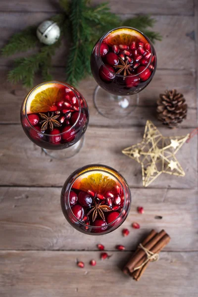 Red Sangria with oranges, pomegranate seeds, cranberry, rosemary and spices - homemade festive drink mulled wine for Christmas time.