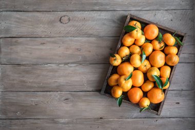 Mandalina (portakal, clementines, narenciye) ahşap arka plan, kopya alanı kutusunda yeşil yaprakları ile.