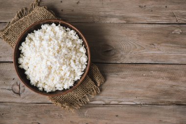 Organik Tarım süzme peynir rustik ahşap arka plan, kopya alanı üzerinde. Ev yapımı peynir için sağlıklı bir diyet yemek yeme.