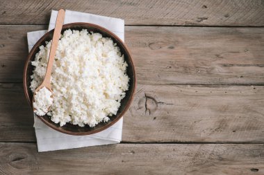 Organik Tarım süzme peynir rustik ahşap arka plan, kopya alanı üzerinde. Ev yapımı peynir için sağlıklı bir diyet yemek yeme.