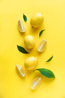 Limon sarı arka plan, üstten görünüm, üzerinde yeşil yaprakları ile lay düz. Organik taze narenciye limon, en az kavramsal düz yatıyordu.