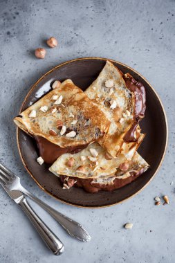 Krep çikolata yayıldı ve fındık ile. Kahvaltı veya tatlı, ev yapımı ince krepler yakın çekim.