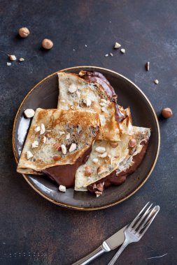 Krep çikolata yayıldı ve fındık ile. Kahvaltı veya tatlı, ev yapımı ince krepler yakın çekim.