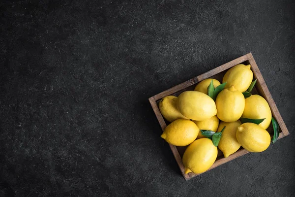 Limones Con Hojas Verdes Caja Sobre Fondo Negro Rústico Vista — Foto de Stock