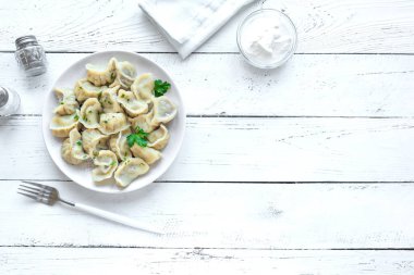 Üstten görünüm, beyaz tahta masada ekşi krema ile ev yapımı et köfte alanı kopyalayın. Taze köfte veya Postickers plaka üzerinde.