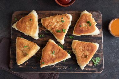 Derin yağda kızartılmış etli turtalar, samsa, samosas, echpochmak - geleneksel et dolması turta ya da vejetaryen kekler rustik arka planda, üstten görünüm.