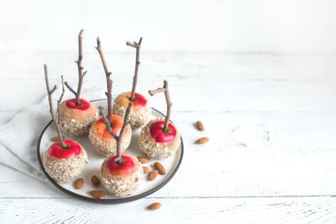 Beyaz ahşap arka planda, kış tatilleri için sopa üzerinde karamelli elma alan kopyalayın. Organik Snack, sağlıklı ev yapımı vegan tatlı - karamelli elma badem ile.