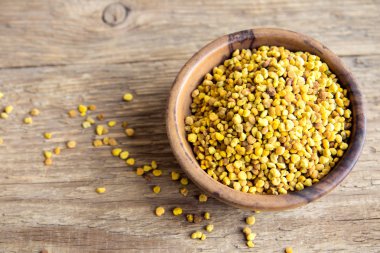 Arı polen kase ahşap arka plan üzerinde. Sağlıklı organik ham diyet vejetaryen gıda içerikler, superfood - arı polen.