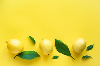 Limon sarı arka plan, üstten görünüm, üzerinde yeşil yaprakları ile alanı kopyalayın. Organik taze narenciye limon, en az kavramsal düz yatıyordu.