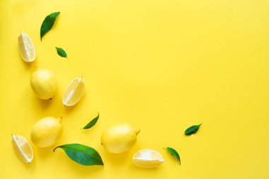 Limon sarı arka plan, üstten görünüm, üzerinde yeşil yaprakları ile alanı kopyalayın. Organik taze narenciye limon, en az kavramsal düz yatıyordu.