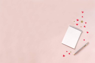 Defter ve kalem kırmızı kalpler, pembe bir arka plan üzerinde yıldız ile alanı kopyalayın. Pembe masanın üzerinde planlama Sevgililer günü, aşk ve romantizm kavramı, en iyi görünüm için en az düz yatırın.