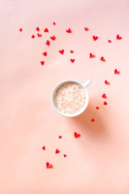 Bir fincan kahve ve kırmızı kalpler pembe, kopya alanı izole. En az düz cappuccino kahve ile yatıyordu Sevgililer günü, aşk ve romantizm kavramı, en iyi görünüm için.