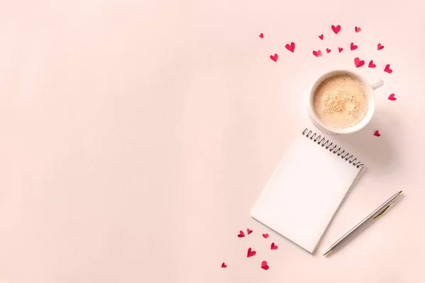 一杯のコーヒー ノートブックを開くとコピー領域 ピンク ベージュの背景の赤いハート 最小フラット カプチーノ コーヒーを置くとバレンタイン日テキスト 愛とロマンスの概念 上から見るのための本 — ストック写真