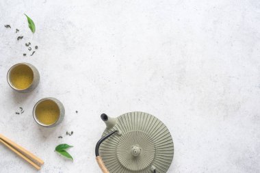 Asya çay seti - demir demlik ve yeşil çay yaprakları ile Seramik çay bardaklarından. Beyaz arka plan, kopya alanı geleneksel çay kompozisyonu.