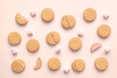 Cookies biscuits crackers and marshmallows flat lay on beige background, top view.