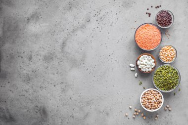 Kase, mercimek, barbunya fasulyesi, nohut, mung, beton zemin, üstten görünüm, üzerine bezelye içinde renkli baklagiller ürün yelpazesine alanı kopyalayın. Sağlıklı gıda, diyet, beslenme kavramı, vegan protein kaynağı.