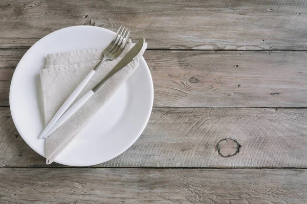 空桌子设置 普通白色陶瓷板 亚麻餐巾 木制桌子上的餐具 禁食的概念 北欧风格 — 图库照片